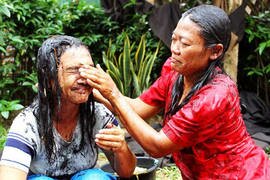 A mother washes her daughter's hair with rice straw ashes in Pabuaran, Central Java, one day before Ramadan. It is a tradition said to cleanse heart and mind. [Andhika Bhakti/Khabar]