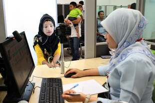 A Thai Muslim woman applies for her travel documents at the passport office in Yala. Opened four years ago, the facility is staffed with Patani Malayu language speakers and offers a range of services designed to help travelers. [Ahmad Ramansiriwong/Khabar]