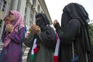 Muslims recite prayers during a demonstration against a Malaysian Catholic newspaper using the word 'Allah' at a Putrajaya court Tuesday (October 14th). In a case that sparked attacks on church riots three years ago, an appeals panel ruled the newspaper could not use the word. [Mohd Rasfan/AFP]