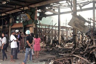 People gather at the SuperCheap market in Phuket on Thursday (October 17th) after it was destroyed in an overnight fire. Residents described reports of no casualties as 