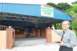 Mosque committee deputy chairman Fadzli Cheah Abdullah points at the old Muhammadiah Mosque building. He and fellow congregants are gently introducing Chinese culture to Malay Muslims, hoping to show that religion and culture need not clash. [Grace Chen/Khabar]