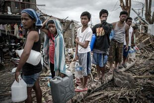 Haiyan survivors stand in line for drinking water in Palo on the outskirts of Tacloban, on the eastern island of Leyte on November 17th. ASEAN and the United States have been working to reach millions of victims with deliveries of food, water and medical supplies. [Philippe Lopez/AFP]