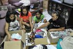 Kuala Lumpur resident Virgie Florendo (far right) and friends sort donations of canned food and clothes for victims of Super Typhoon Haiyan. The Manila native asked her Malaysian father-in-law, a taxi driver, to take the donations to the Philippines Embassy. [Grace Chen/Khabar] 