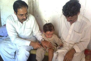 A doctor in Peshawar, Pakistan examines a boy on November 10th who recently contracted polio. Ceding to militant demands the boy's parents did not vaccinate him. [Ashfaq Yusufzai]