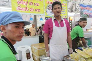 Sarayuth Singkha (centre) is the business manager of a Muslim community group in Ayutthaya, north of Bangkok. The group was doing brisk business selling roti sai mai (new style roti) at the OTOP exhibition, which helps Muslims throughout the Kingdom get to know one another, he said. [Somchai Huasaikul/Khabar]