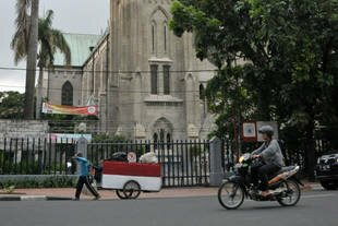 A man pulls his cart past Jakarta's Catholic Church Cathedral on Thursday (December 12th). Islamic extremists may be planning to target Christmas worshippers and New Year celebrations in Jakarta and other parts of Indonesia, police warned. [Bay Ismoyo/AFP]