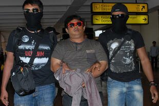 Counterterrorism police on Tuesday (December 17th) guard a terror suspect from eastern Indonesia at Jakarta's Soekarno-Hatta airport. A man arrested Monday in Bima, West Nusa Tenggara is suspected of accepting Rp 47 billion ($3.8m) from the Abu Roban terror group to recruit people for military training in Poso, Central Sulawesi, police say. [Bima Sakti/AFP]