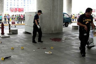 Police inspect the crime scene after gunmen opened fire outside Manila International Airport on Friday (December 20th), killing Labangan Mayor Ukol Talumpa, his wife, an 18-month-old grandson and an aide. Travellers scattered during the attack, reportedly the third attempt on the life of the mayor of the southern Philippines town. [AFP]