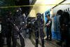 Densus 88 officers on January 20th surround a house in Surabaya rented by a suspected terrorist. [Juni Kriswanto/AFP]