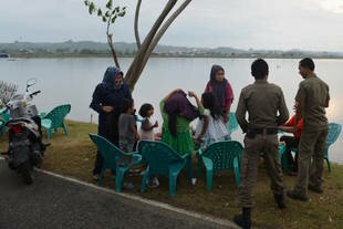 Sharia police check on women in a park in Lhokseumawe, Aceh in April 2013. The provincial administration has approved a bylaw requiring adherence to sharia law by Muslims and non-Muslims. [Chaideer Mahyuddin/AFP]