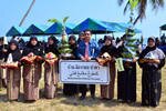 Residents of Mengabang Pantai Village hold a new sign on February 9th listing the village's name in (from top to bottom) Thai, Pattani Malay (rendered in Jawi script) and English. [Ahmad Ramansiriwong/Khabar]
