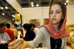 A woman offers samples of Iranian dates at the Malaysian International Halal Showcase in Kuala Lumpur in May 2007. Recent enactments of policies targeting drug smugglers and illegal emigres have had an impact on Iranians working or studying in Malaysia. [Tengku Bahar/AFP]