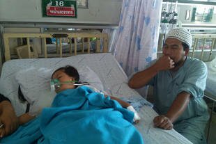 Niloh Uma sits bedside as his 3-year old daughter Noorhasin recovers after almost drowning at a beach in Narathiwat Province. [Rapee Mama/Khabar]