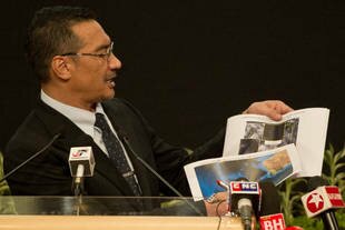 Transport Minister Hishammuddin Hussein shows pictures of possible debris from missing Malaysia Airlines Flight 370 in Kuala Lumpur on Wednesday (March 26th). [Mohd Rasfan/AFP]