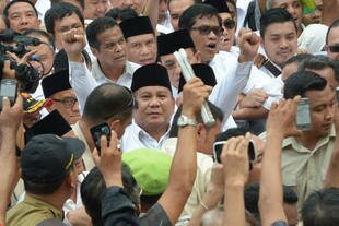 Gerindra Party leader Prabowo Subianto (centre) salutes supporters Tuesday (May 20th) as he heads to the General Elections Commission (KPU) office in Jakarta to register his presidential candidacy. [Adek Berry/AFP]