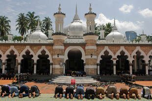 Malaysians pray at the Jamek Mosque in Kuala Lumpur on May 9th. [Mohammad Rasfan/AFP]