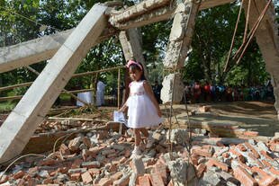 A girl walks across Taman Sari Batak Christian Protestant church in Bekasi, Indonesia in March 2013 after local officials bulldozed the building. On Tuesday (June 3rd), Christians from Cianjur, West Java filed complaints with the National Commission on Human Rights (Komnas HAM) about the forced closure of churches in their city. [Adek Berry/AFP]