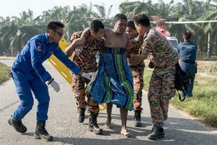 A Malaysian search-and-rescue team on Thursday (June 19th) helps a survivor of a boat that capsized Wednesday in Kelanang Jetty. Authorities said Friday they arrested two Indonesians in connection with one of this week's two boat accidents. [Mohd Rasfan/AFP]