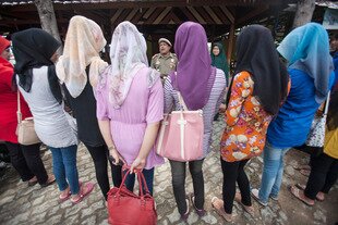  An Acehnese official speaks to students wearing tight trousers in September 2013. Now, the Indonesian Ulema Council (MUI) issued a fatwa banning tight-fitting tops. [Chaideer Mahyuddin/AFP] 