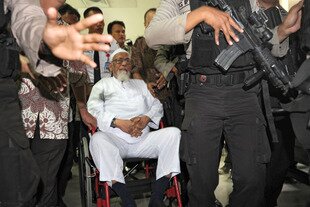  Police escort Abu Bakar Bashir to a hospital in Jakarta for cataracts surgery in February 2012. Bashir's sons earlier this month fell out with their father over his call for allegiance to the Islamic State in Iraq and Syria (ISIS). [Romeo Gacad/AFP] 