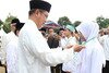  Menteri Agama Indonesia, Lukman Hakim Saifuddin, kiri, mengalungkan medali kepada seorang peserta di kamp nasional anggota dewan Himpunan Pelajar Islam di Cibubur, Jakarta, pada 12 November. [Maeswara Palupi/Khabar] 