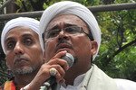 Muhammad Rizieq Shihab (centre), head of the Islamic Defenders Front (FPI), speaks during a rally outside the parliament building in Jakarta on November 10th. The FPI is demanding Jakarta Governor Basuki "Ahok" Tjahaja Purnama be removed from office, and has "inaugurated" its own pick for the governorship. [Adek Berry/AFP] 
